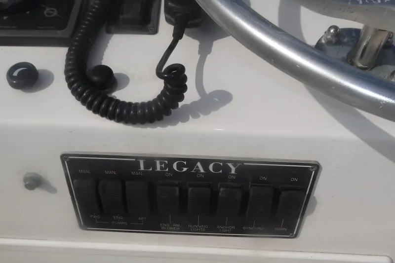 Slide: The Image of Control panel of 1998 Legacy 40' Flybridge boat with switches and steering wheel. - 47