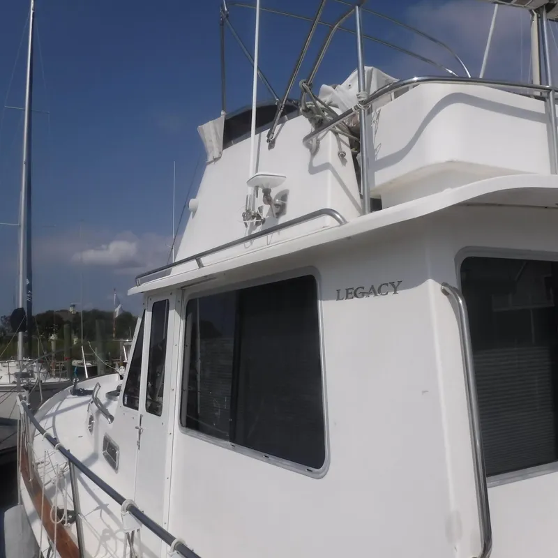 Slide: The Image of 1998 Legacy 40' Flybridge yacht docked under clear skies. - 5