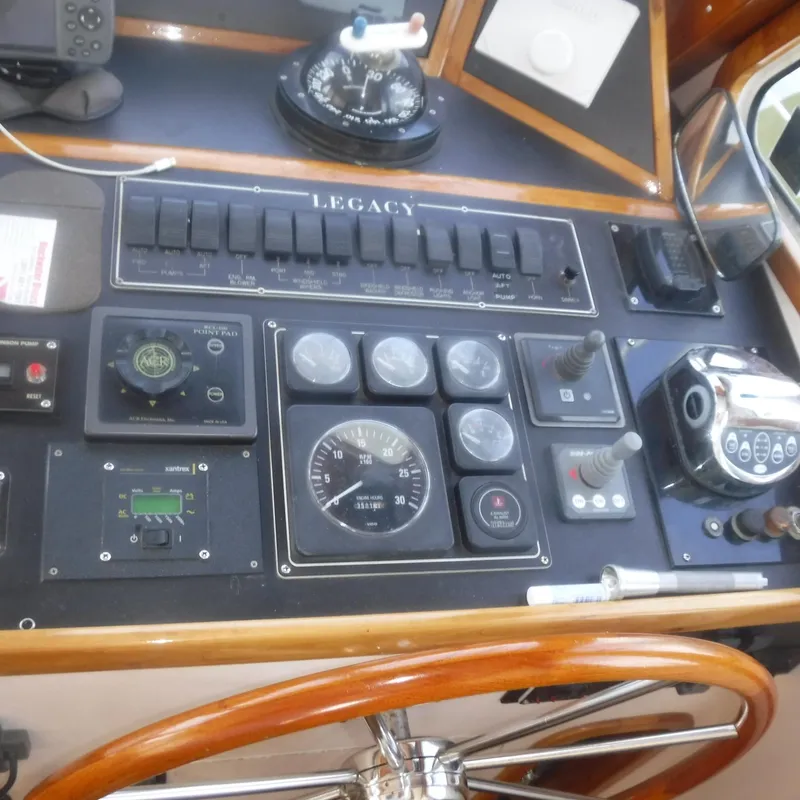 Slide: The Image of Control panel of a 1998 Legacy 40' Flybridge boat with gauges and switches. - 6