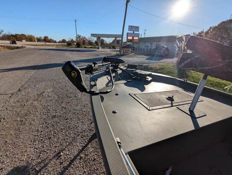 Slide: The Image of 2023 Tracker Grizzly 1648 SC boat parked near a gas station under a clear sky. - 13