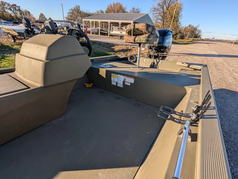 Slide: The Image of 2023 Tracker Grizzly 1648 SC boat with motor, parked outdoors on a sunny day. - 14