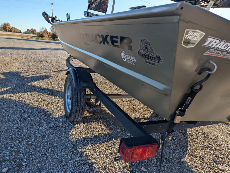Slide: The Image of 2023 Tracker Grizzly 1648 SC boat on trailer, parked on gravel. - 5