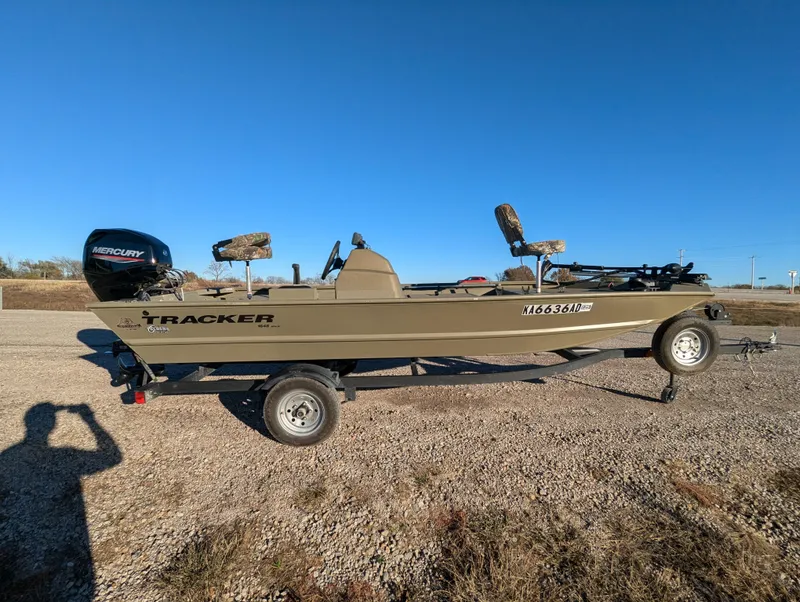 Slide: The Image of 2023 Tracker Grizzly 1648 SC boat on trailer, outdoors under clear blue sky. - 9