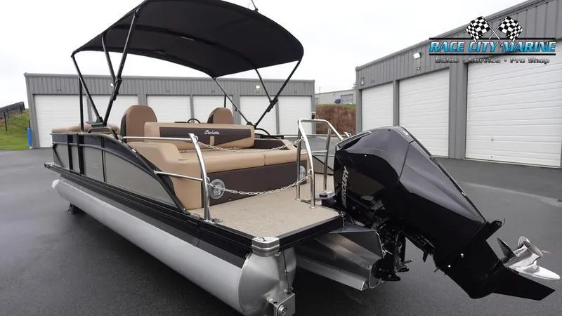 Slide: The Image of 2025 Barletta C22UC pontoon boat with canopy and outboard motor in a storage facility. - 7