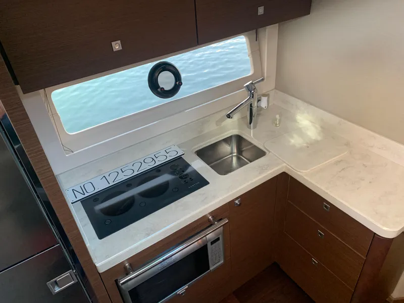 Slide: The Image of Modern kitchen in 2014 Sea Ray 410 Sundancer yacht with stove, sink, and microwave. - 26
