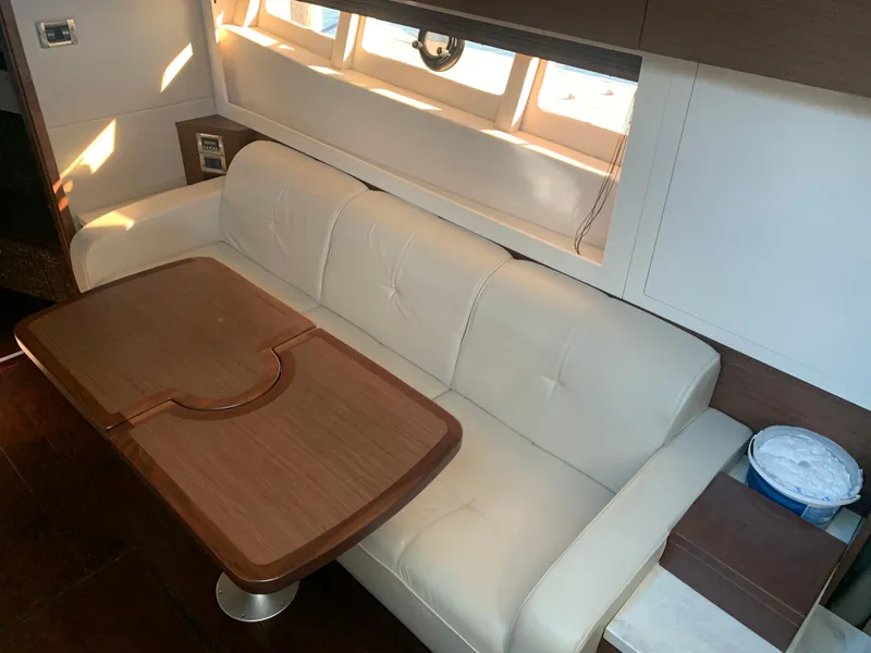 Slide: The Image of Interior of 2014 Sea Ray 410 Sundancer with white sofa and wooden table. - 28
