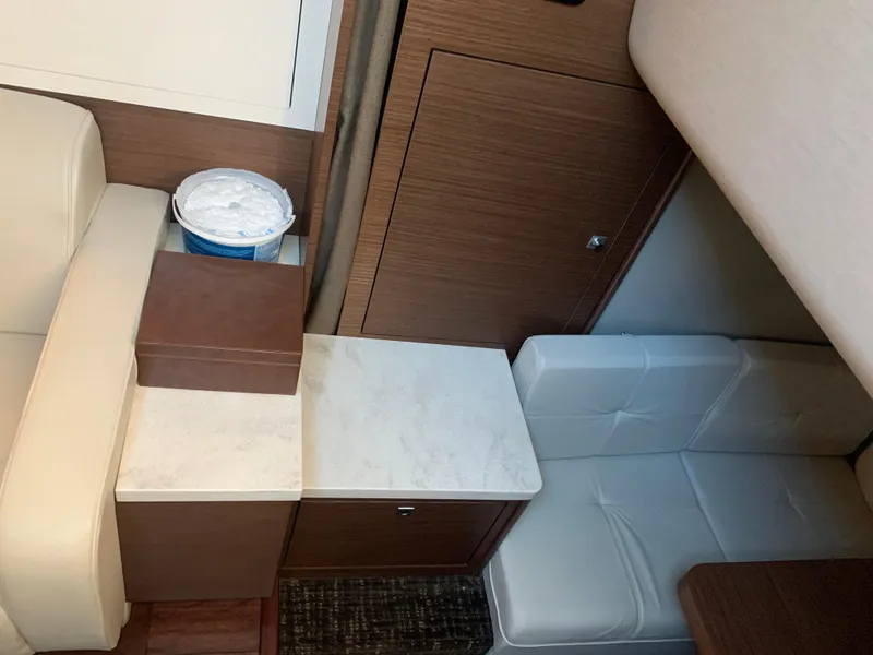 Slide: The Image of Interior of 2014 Sea Ray 410 Sundancer with beige seating and wooden cabinetry. - 29