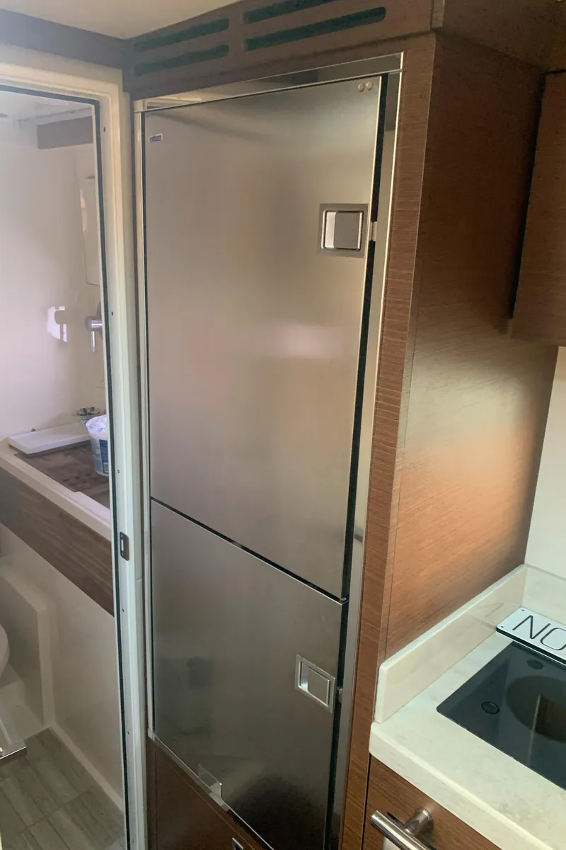 Slide: The Image of 2014 Sea Ray 410 Sundancer yacht interior with modern kitchen and stainless steel fridge. - 35