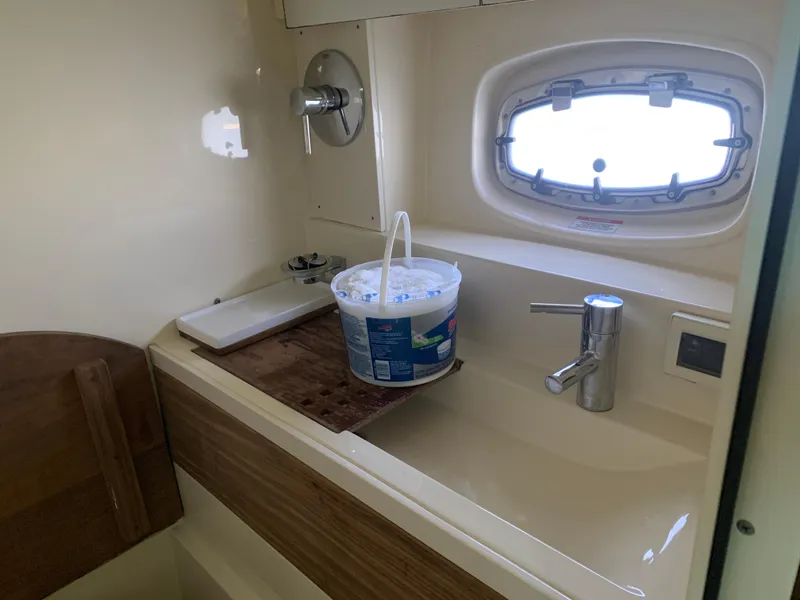 Slide: The Image of 2014 Sea Ray 410 Sundancer bathroom with sink and porthole window. - 39