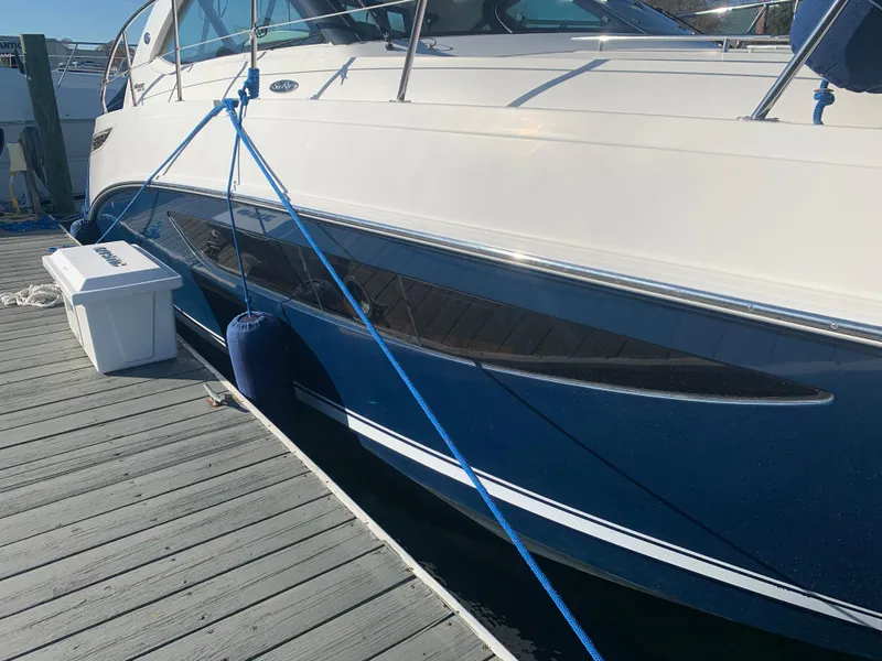Slide: The Image of 2014 Sea Ray 410 Sundancer yacht docked with blue hull and white deck. - 4