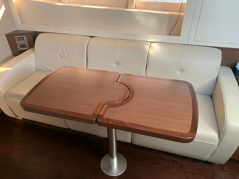 Slide: The Image of Luxurious interior of 2014 Sea Ray 410 Sundancer with elegant wooden table and white leather seating. - 41