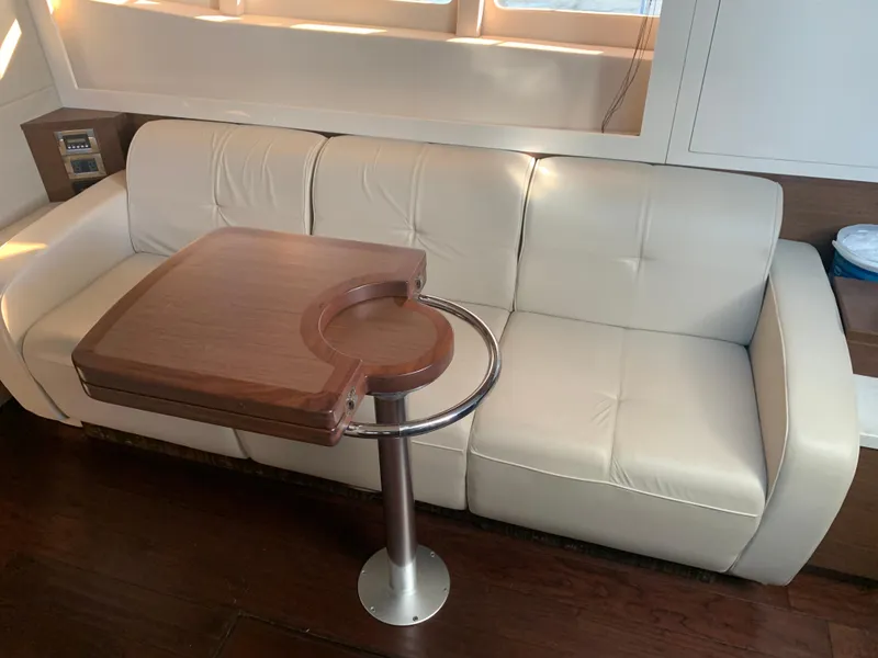 Slide: The Image of Luxurious interior of 2014 Sea Ray 410 Sundancer with cream sofa and wooden table. - 42