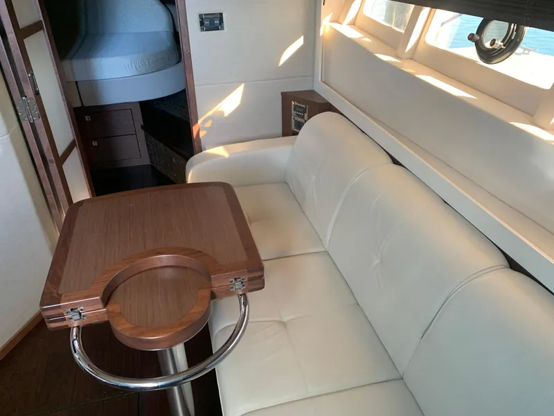 Slide: The Image of Luxurious interior of 2014 Sea Ray 410 Sundancer with white seating and wooden table. - 43