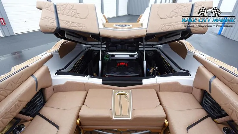 Slide: The Image of 2025 Nautique Super Air Nautique G23 Paragon interior with tan upholstery and open storage compartments. - 26