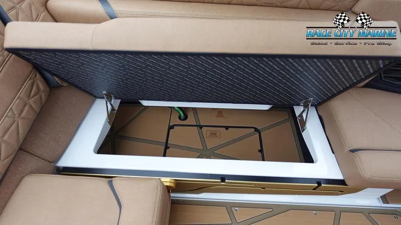 Slide: The Image of 2025 Nautique Super Air G23 Paragon storage compartment with open seat, Race City Marine logo. - 34