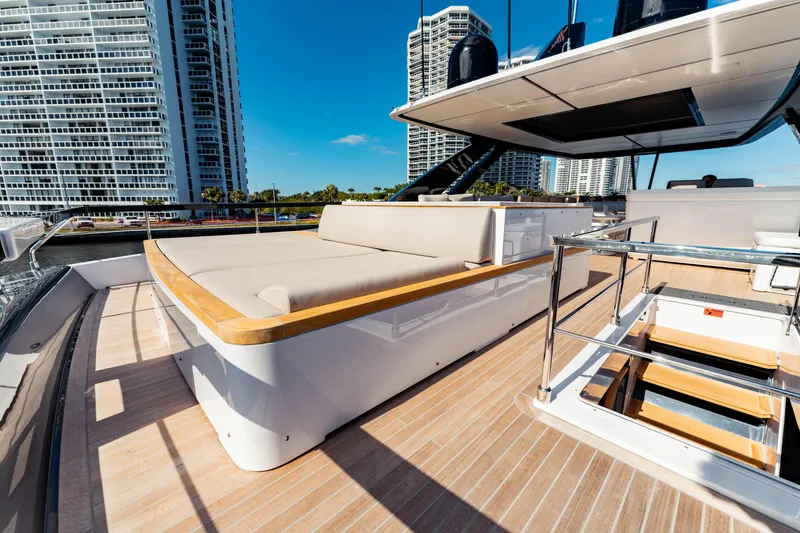 Slide: The Image of Luxurious 2023 Ferretti Yachts 860 deck with modern seating and cityscape backdrop. - 16