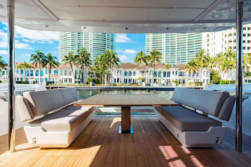 Slide: The Image of Luxurious 2023 Ferretti Yachts 860 deck with seating, overlooking waterfront and palm trees. - 20