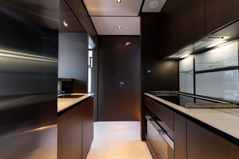 Slide: The Image of Luxurious modern kitchen interior on 2023 Ferretti Yachts 860, featuring sleek dark cabinetry. - 47