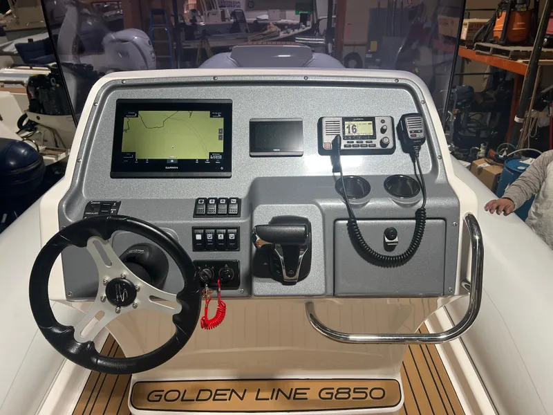 Slide: The Image of 2024 Grand Goldenline 850 boat dashboard with steering wheel and navigation controls. - 11