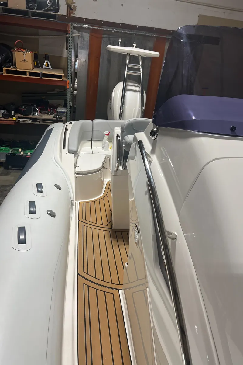 Slide: The Image of 2024 Grand Goldenline 850 boat with sleek design and wooden deck in a garage setting. - 14