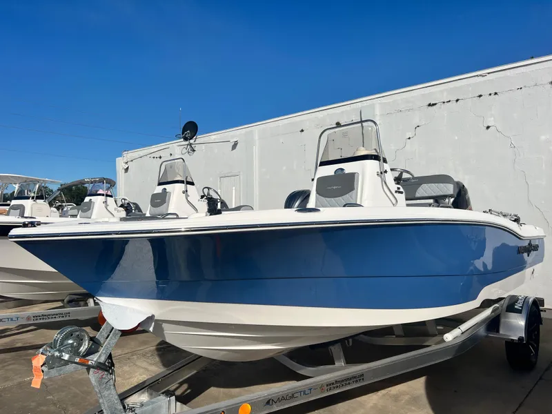 Slide: The Image of 2025 NauticStar 191 Hybrid boat in blue and white on a trailer. - 1