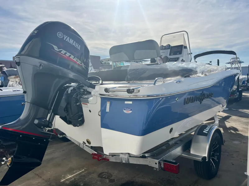 Slide: The Image of 2025 NauticStar 191 Hybrid boat with Yamaha outboard motor, parked on a trailer. - 2