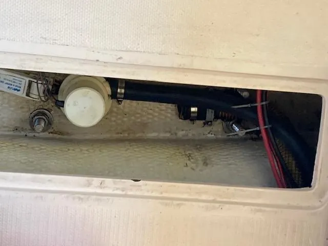 Slide: The Image of 1989 Catalina 30 boat interior showing plumbing and wiring components. - 10