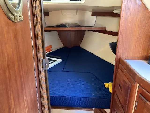 Slide: The Image of 1989 Catalina 30 sailboat interior with blue cushions and wooden cabinetry. - 13