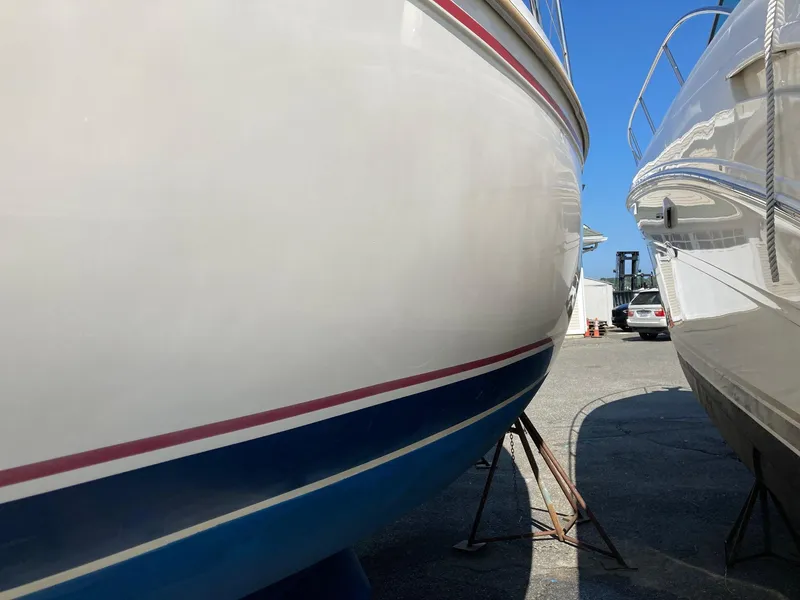 Slide: The Image of 1989 Catalina 30 sailboat hulls on stands in a marina under clear blue sky. - 22