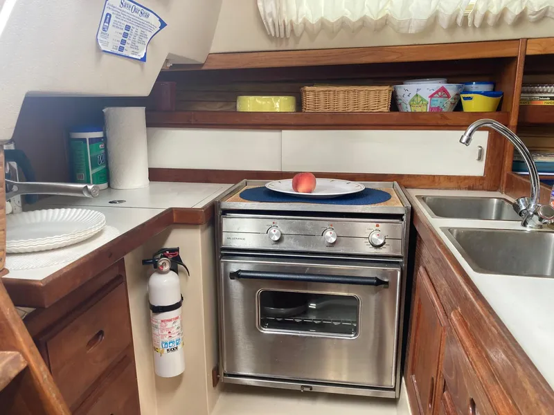 Slide: The Image of Compact kitchen in a 1989 Catalina 30 sailboat with stove, sink, and storage. - 24