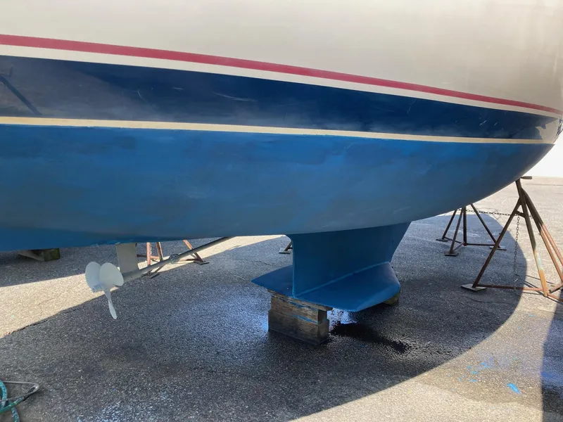 Slide: The Image of 1989 Catalina 30 sailboat hull and keel on stands, blue and white paint. - 28