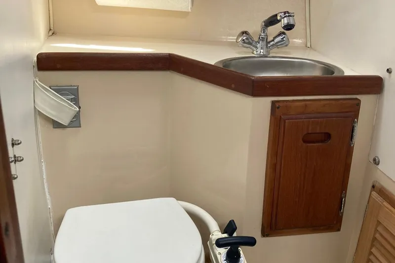 Slide: The Image of Catalina 30 yacht bathroom with sink, toilet, and wooden cabinet, 1989 model. - 30