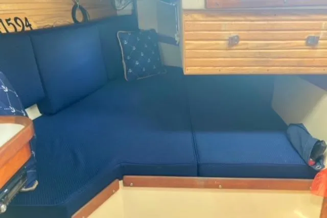 Slide: The Image of Interior of a 1989 Catalina 30 sailboat with blue cushioned seating. - 34
