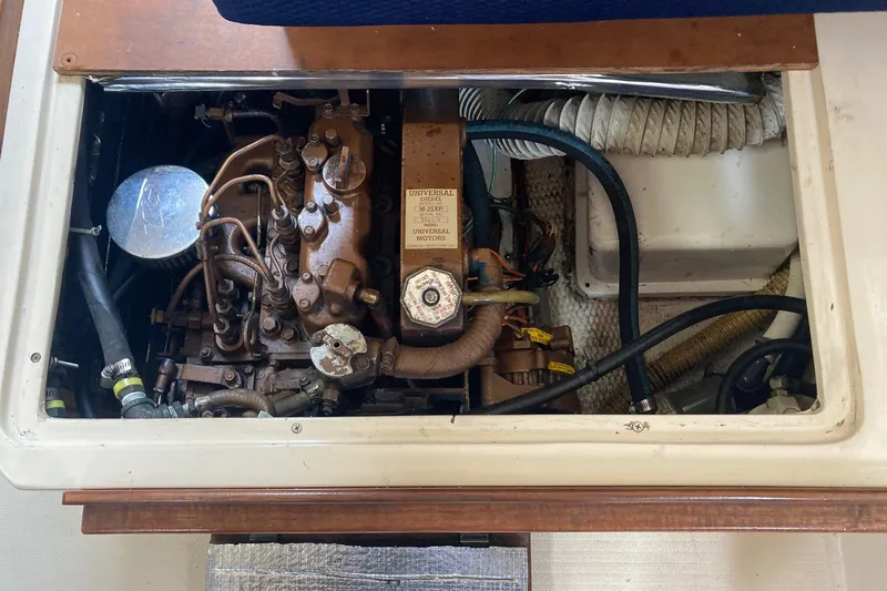 Slide: The Image of Engine compartment of a 1989 Catalina 30 sailboat, showcasing mechanical components and hoses. - 36