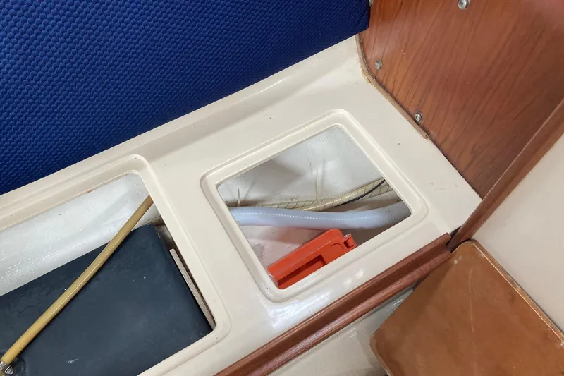 Slide: The Image of Interior view of a 1989 Catalina 30 sailboat showing storage compartment and seating area. - 38