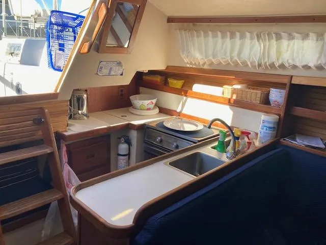 Slide: The Image of Interior of a 1989 Catalina 30 sailboat kitchen with wooden cabinetry and appliances. - 4