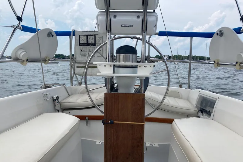 Slide: The Image of Cockpit of 1989 Catalina 30 sailboat with steering wheel and seating, on calm water. - 43