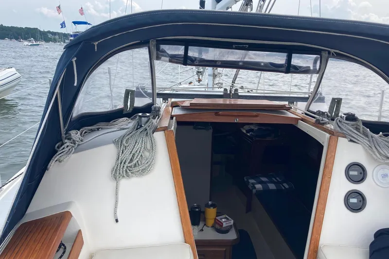 Slide: The Image of 1989 Catalina 30 sailboat cockpit with ropes and cabin entrance on a calm lake. - 47