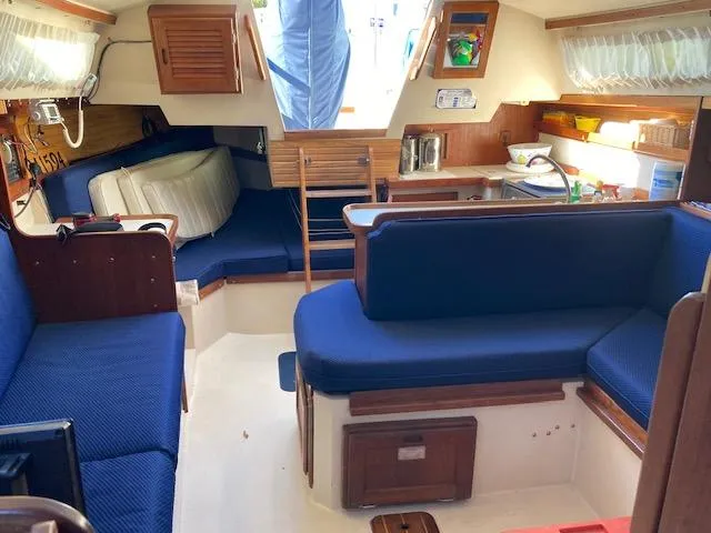 Slide: The Image of Interior of a 1989 Catalina 30 sailboat with blue seating and wooden accents. - 5