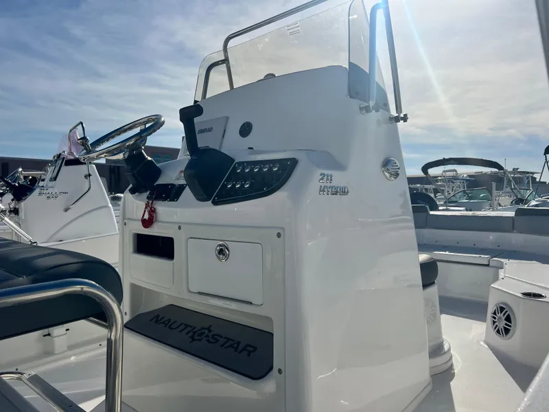 Slide: The Image of 2025 NauticStar 211 Hybrid boat console with steering wheel and controls. - 13