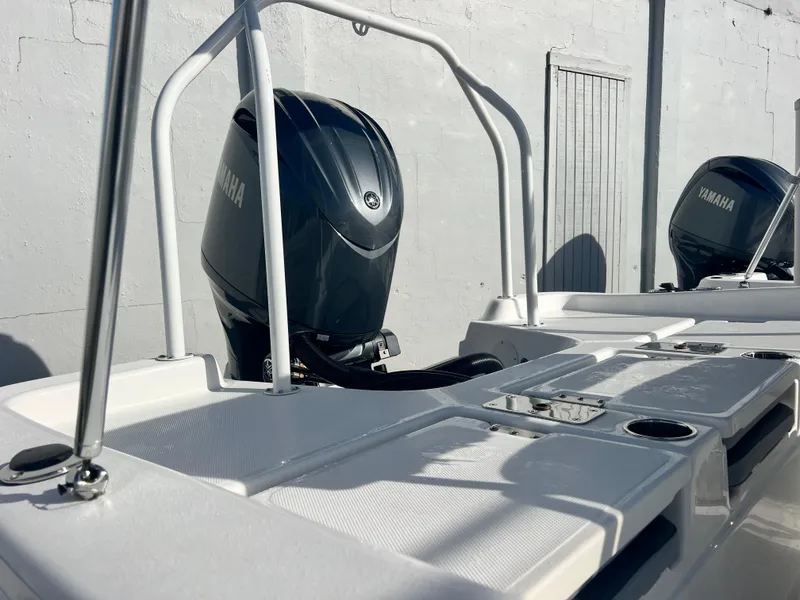 Slide: The Image of 2025 NauticStar 211 Hybrid boat with Yamaha outboard motor, docked outdoors. - 14