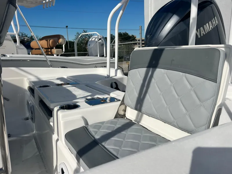 Slide: The Image of 2025 NauticStar 211 Hybrid boat interior with Yamaha engine, featuring gray seating and console. - 5