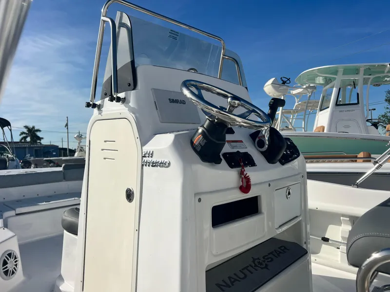 Slide: The Image of 2025 NauticStar 211 Hybrid boat console with steering wheel and controls. - 7