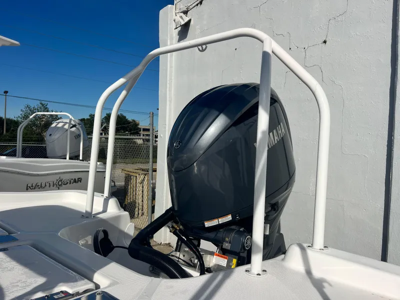 Slide: The Image of 2025 NauticStar 211 Hybrid boat with Yamaha outboard motor, docked outdoors. - 8