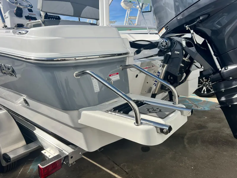 Slide: The Image of 2025 NauticStar 211 Hybrid boat with outboard motor and swim ladder. - 9