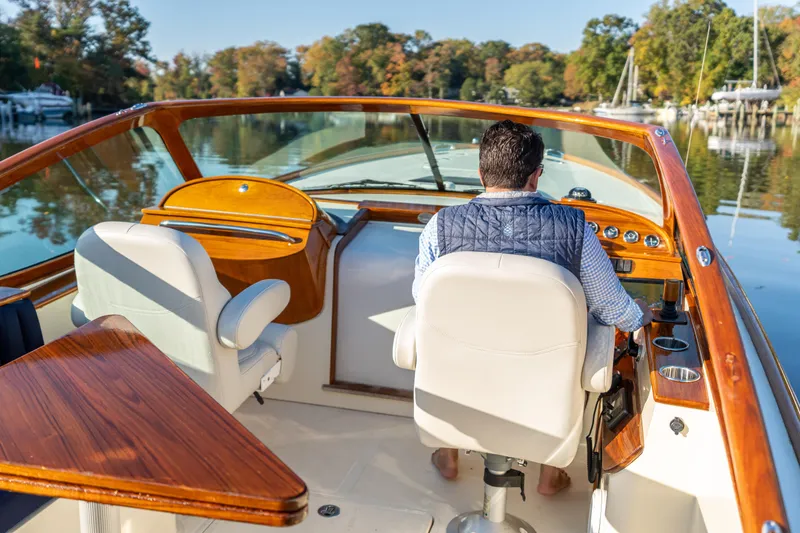 Slide: The Image of Man steering 2003 Hinckley Talaria 29 Runabout on a calm river. - 15