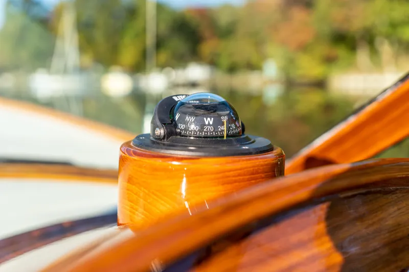 Slide: The Image of Compass on 2003 Hinckley Talaria 29 Runabout, showcasing polished wood finish. - 25