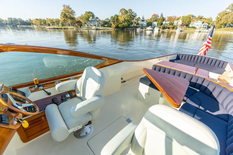Slide: The Image of 2003 Hinckley Talaria 29 Runabout on calm water, featuring elegant seating and wooden accents. - 27