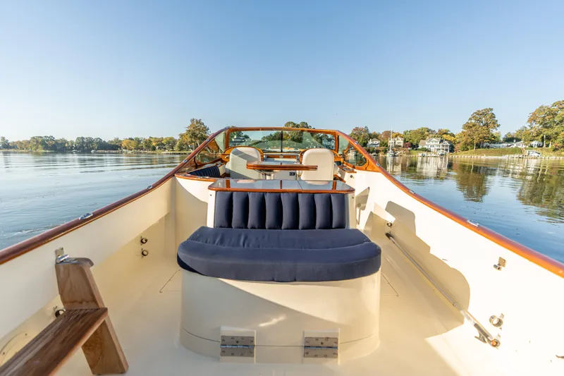 Slide: The Image of 2003 Hinckley Talaria 29 Runabout on calm water, featuring elegant seating and classic design. - 31