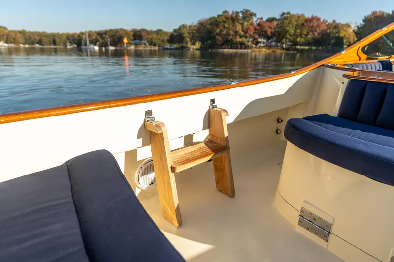 Slide: The Image of 2003 Hinckley Talaria 29 Runabout interior with blue seating, wooden accents, and scenic water view. - 34